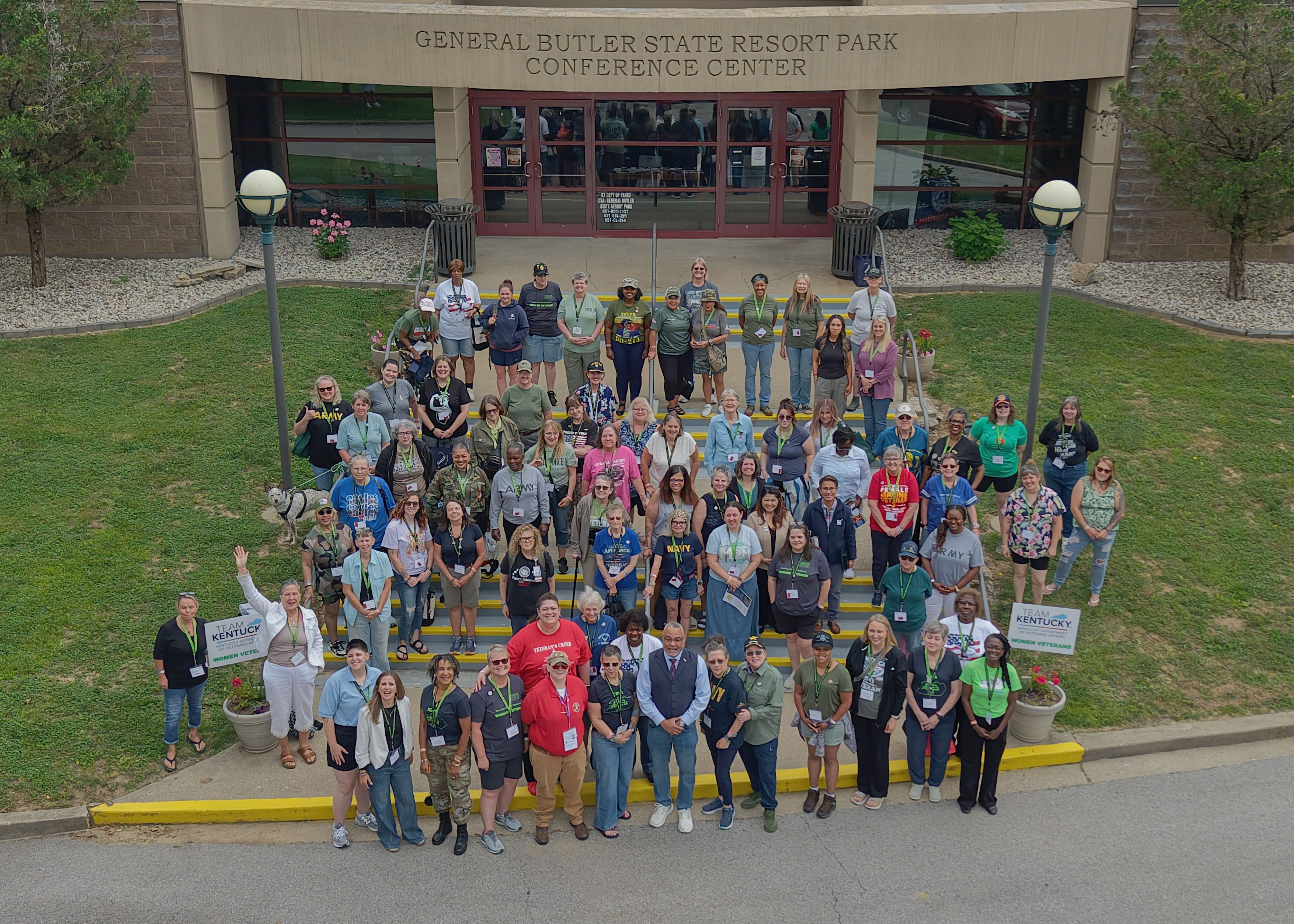 A large group photo wof women in front of the entrance to the Gen Butler State Park Conference Center.